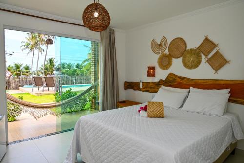 a bedroom with a bed with a view of the ocean at Pousada Estação do Mar in Japaratinga