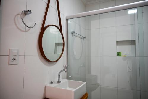 uma casa de banho branca com um lavatório e um espelho em Pousada Estação do Mar em Japaratinga