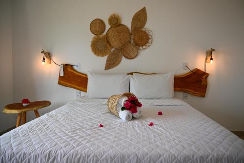 a bed with a stuffed animal with flowers on it at Pousada Estação do Mar in Japaratinga