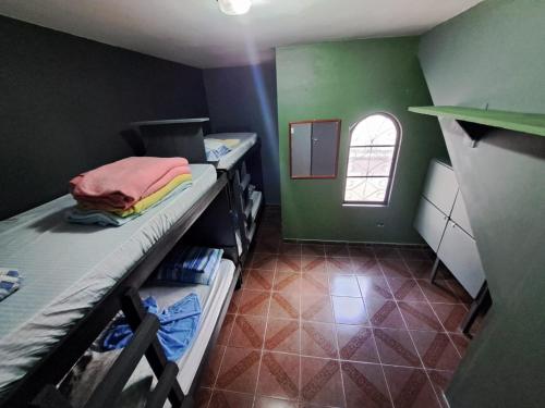 Zimmer mit 2 Etagenbetten und einer grünen Wand in der Unterkunft RustiCidade in São Paulo