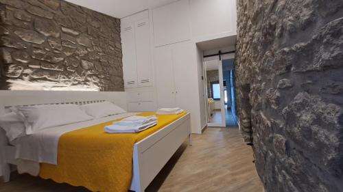 1 dormitorio con cama y pared de piedra en Alloggio turistico Pietra Viva en Vitorchiano