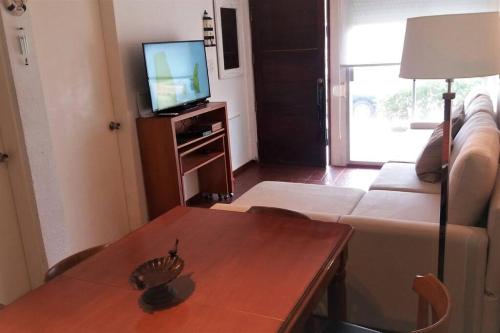 uma sala de estar com um sofá, uma mesa e uma televisão em Apartamento para familia o parejas em Punta del Este