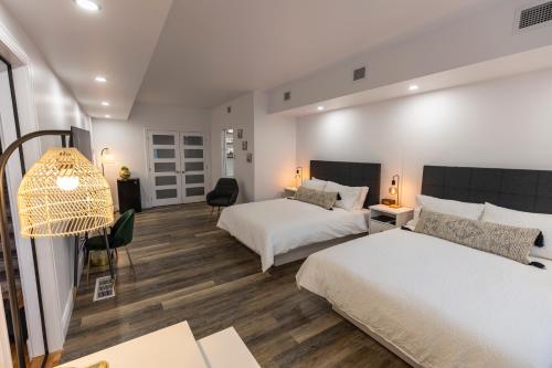 a hotel room with two beds and a desk at Auberge Nouvelle-France in Ville-Marie