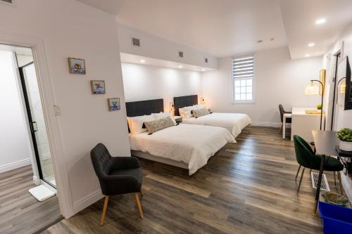 1 dormitorio con 2 camas, escritorio y silla en Auberge Nouvelle-France en Ville-Marie