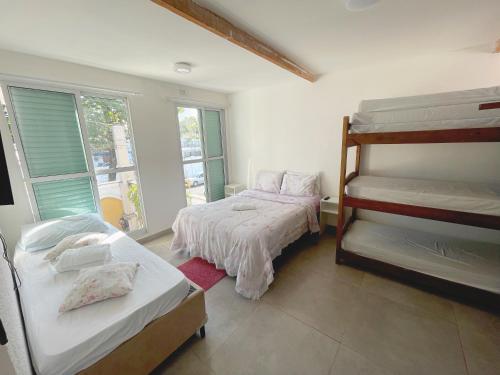a bedroom with two bunk beds and a window at Blue Hale in Guarujá