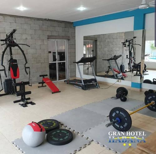 um ginásio com muitos equipamentos de exercício numa sala em Hotel Gran Habana em Termas de Río Hondo