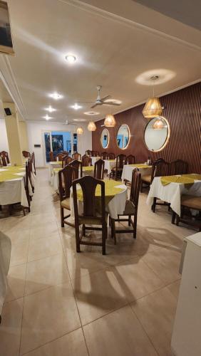ein Esszimmer mit Tischen, Stühlen und Spiegeln in der Unterkunft Hotel Gran Habana in Termas de Río Hondo