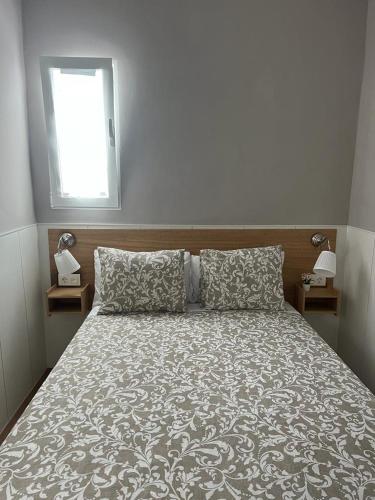 1 dormitorio con 1 cama, ventana y 2 mesitas de noche en Casa Rural "El Patio de Paca" en Tegueste