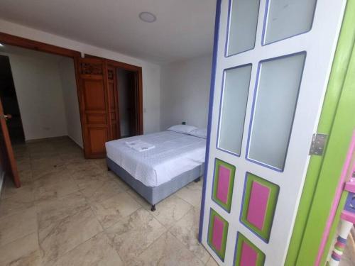a small bedroom with a bed and a door at casa antioquia in Circasia