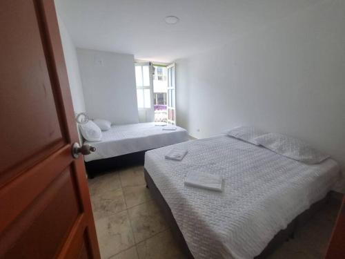 a small bedroom with two beds and a window at casa antioquia in Circasia