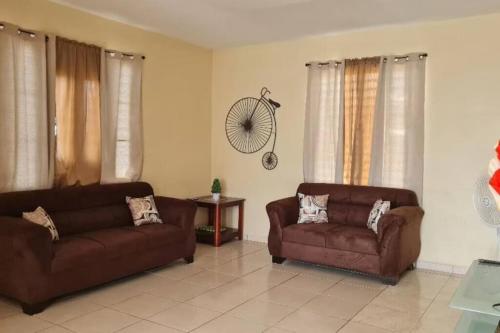 a living room with two brown couches and a chair at Colinas del Atlantico Vacational House 2nd Floor in Isabela
