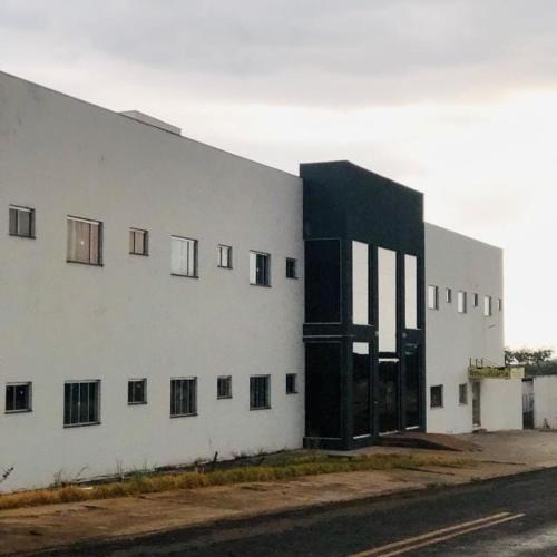 a white building with a black door on the side of it at Hotel Cruzeiro de São José in São Francisco de Goiás