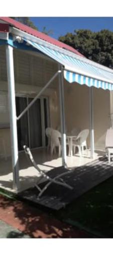 德豪特漁村的住宿－Duplex bord de mer，门廊上设有椅子和屋顶,