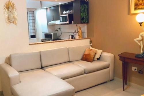 uma sala de estar com um sofá e uma cozinha em Hermoso depto, a pasos de todo. em Corrientes