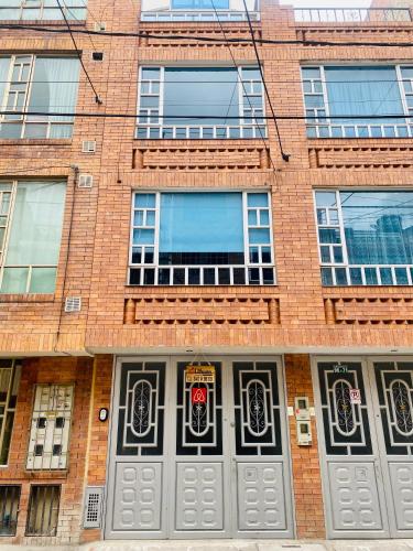 - un bâtiment en briques avec des portes et des fenêtres grises dans l'établissement Habitacion cerca al aeropuerto el dorado, à Bogotá