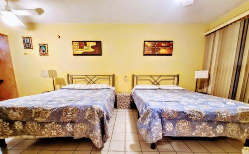 2 camas en una habitación con paredes amarillas en Departamentos Varmen, en La Paz