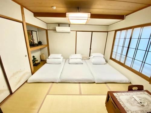 1 dormitorio con 2 camas en una habitación con ventanas en Reynaville 4F / Vacation STAY 2134, en Tokushima