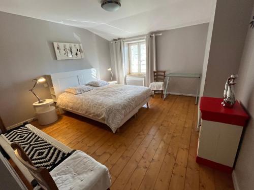 a bedroom with a bed and a red table and chairs at Gîte de Charme avec Terrasse près de Bourbonne-les-Bains, 2 chambres, poêle à bois, Wifi inclus - FR-1-589-118 in Lironcourt