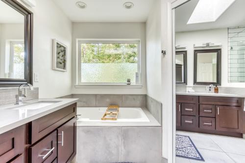 a bathroom with a tub and a sink and a window at Raleigh Hills Retreat in Portland
