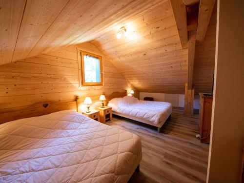 1 Schlafzimmer mit 2 Betten in einer Holzhütte in der Unterkunft Chalet familial confortable avec spa, proche Gérardmer et station de ski, idéal été et hiver. - FR-1-589-469 in Ban-sur-Meurthe-Clefcy