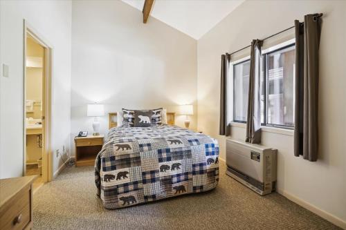 um quarto com uma cama, um lavatório e uma janela em Cedarbrook Queen Suite 203 em Killington