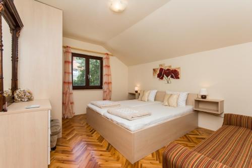 a bedroom with a large bed and a couch at Apartments Šiljug in Cavtat