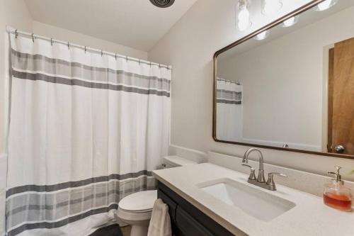 een badkamer met een wastafel, een toilet en een spiegel bij 3 Bed 2 Bath Home w 2 Car Garage & Fitness Room in Wichita