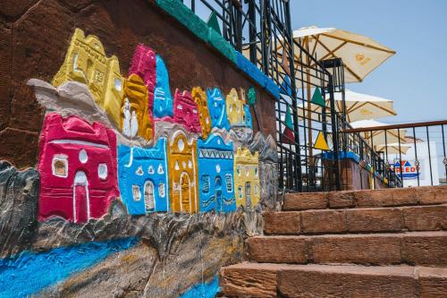 una pared con una pintura de un edificio en ella en Kulih Nubian House, en Shellal