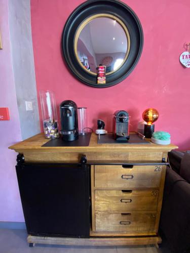 einen Schminktisch mit einem Spiegel an einer rosa Wand in der Unterkunft La Guest beucherie in Romorantin