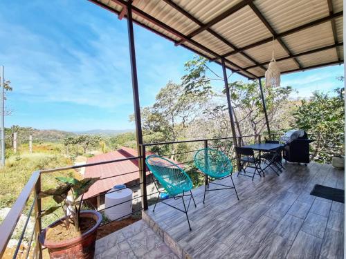 a view from the deck of a house with chairs and a table at Pinilla Highlands Incredible mountain views in Tamarindo