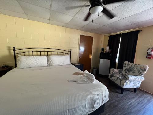 sypialnia z łóżkiem, wentylatorem i krzesłem w obiekcie JI4, King Guest Room at the Joplin Inn at entrance to the resort Hotel Room w mieście Mount Ida