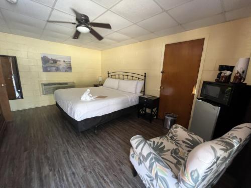 sypialnia z łóżkiem i wentylatorem sufitowym w obiekcie JI4, King Guest Room at the Joplin Inn at entrance to the resort Hotel Room w mieście Mount Ida