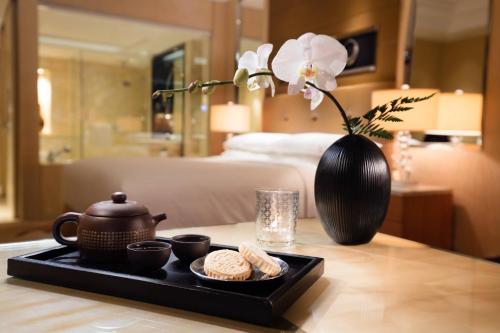 a tray with a tea pot and cookies on a table at Guangzhou Marriott Hotel Tianhe in Guangzhou