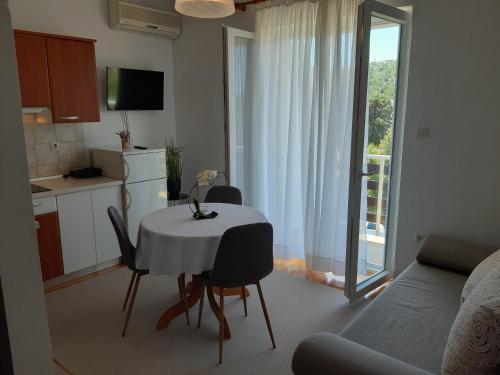 a kitchen with a table and chairs and a kitchen with a window at Apartment Tisno 17716a in Tisno