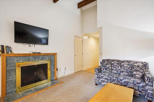 a living room with a couch and a fireplace at Cedarbrook Queen Suite 202 in Killington