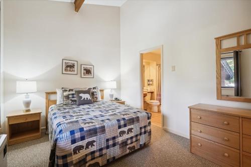 um quarto com uma cama, uma cómoda e um espelho em Cedarbrook Queen Suite 202 em Killington