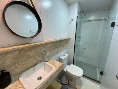 W łazience znajduje się umywalka, lustro i toaleta. w obiekcie Bela Hospedagem - #Puerto Ventura 103A Beira Mar w mieście João Pessoa