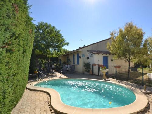 ein Schwimmbad in einem Hof neben einem Haus in der Unterkunft Pretty house with private fenced pool in Clarensac
