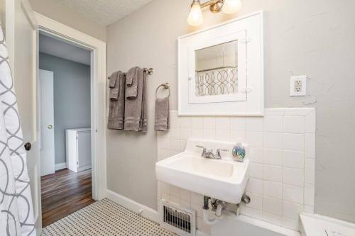 ein weißes Badezimmer mit einem Waschbecken und einem Spiegel in der Unterkunft 3 Bed 1 5 Bath Home By College Hill & Hospitals in Wichita