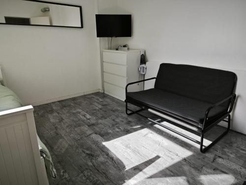 Sofá negro en una habitación con TV en Smart Appart, en Colonia