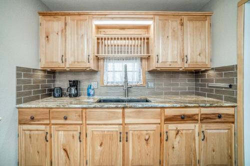 a kitchen with wooden cabinets and a sink at 2 Bed 1 Bath Home w 2 Car Garage & Fenced Yard in Wichita