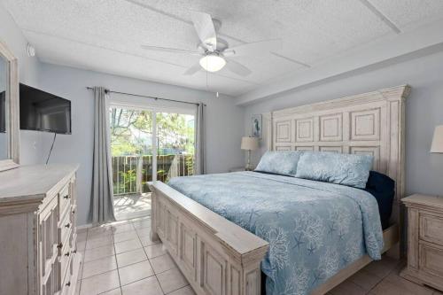 Schlafzimmer mit einem Bett, einem TV und einem Fenster in der Unterkunft 2 Bed 2 Bath 1st Fl Condo By Beach w Washer Dryer in South Padre Island