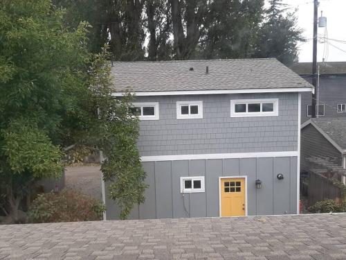 a gray garage with a yellow door on a driveway at Alki Beach Cottage, NEW, 2 bedrooms, 2 bathrooms, near beach, AC, WD, Parking in Seattle