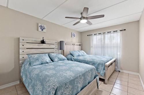 a bedroom with two beds and a ceiling fan at 2 Bed 1 Bath Condo By Beach & Entertainment in South Padre Island