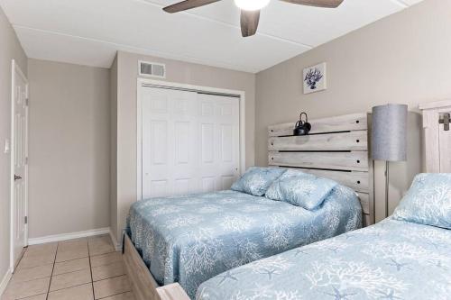 a bedroom with two beds and a white door at 2 Bed 1 Bath Condo By Beach & Entertainment in South Padre Island