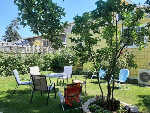 a group of chairs and a table next to a tree at Alki Beach Cottage, NEW, 2 bedrooms, 2 bathrooms, near beach, AC, WD, Parking in Seattle