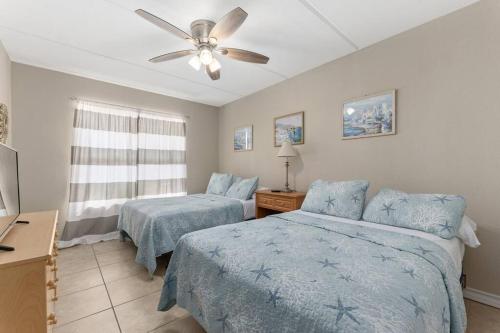 a bedroom with two beds and a ceiling fan at 2 Bed 2 Bath 1st Floor Condo w Pool By Beach in South Padre Island
