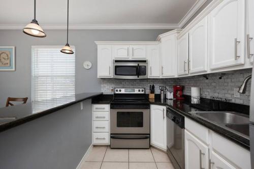 a kitchen with white cabinets and a stove top oven at Luxury 3 Bed 2 Bath 2nd Floor Condo By Beach in South Padre Island