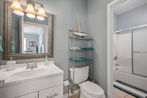 a bathroom with a sink and a toilet and a mirror at Luxury 3 Bed 2 Bath 2nd Floor Condo By Beach in South Padre Island