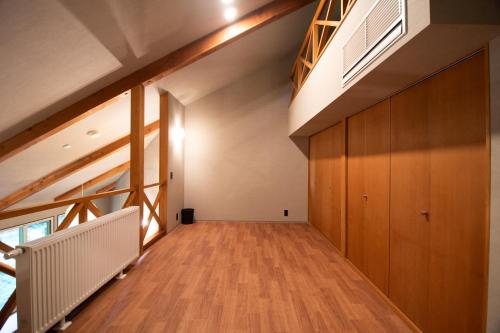an empty hallway with wood floors and a staircase at ユニテ蔵王ジョーニダ リゾート in Yamagata